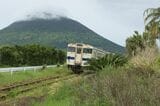 雲に覆われた開聞岳と指宿枕崎線を走るキハ47形（写真：kogata／PIXTA）