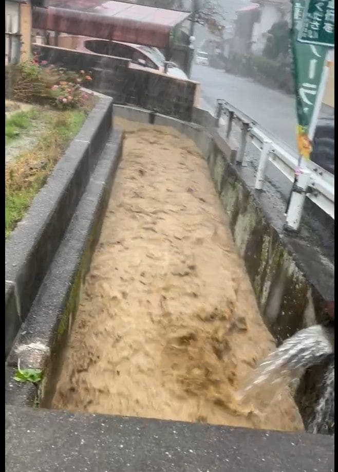 2024年11月の土砂流出直後に椿台の住宅近くの水路を流れ下る濁流（提供：平群のメガソーラーを考える会）
