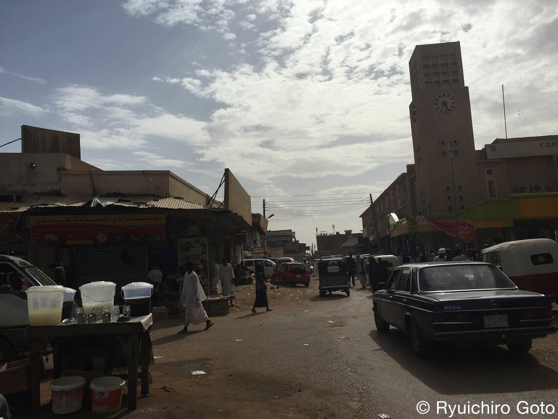 雑居ビルが立ち並ぶ街中には、白いイスラム装束を来た男性が数多くいる（写真：著者提供）