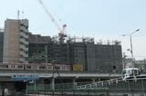 京急本線と建設中のマンション（記者撮影）
