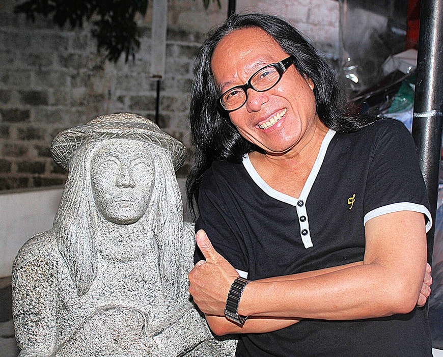 「オロンガポの息子」の彫像の隣に立つフレディ・アギラ氏（写真・2012年11月、柴田直治）