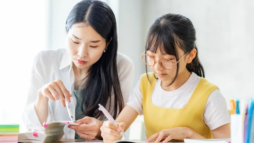 勉強をする小学生と教えるママ