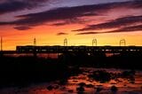 多摩川の夕焼けと京王線＝2015年7月（撮影：南正時）