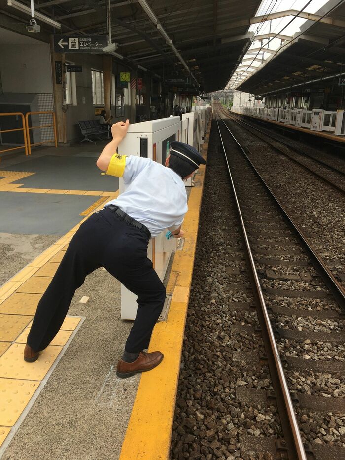 「汚れ検知」のドアを開けてセンサーを清掃する駅係員。