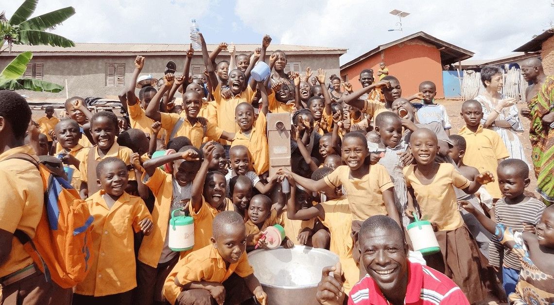 井戸を囲む笑顔の子どたち。明治は2020年までに10基の井戸を寄贈した。どの村でも井戸はとても喜ばれている（写真：明治）