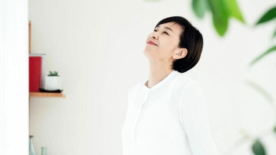 窓辺に立つシニア女性