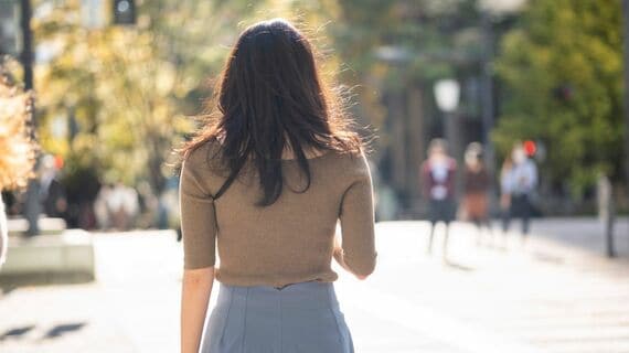 外を歩く働く女性の後ろ姿