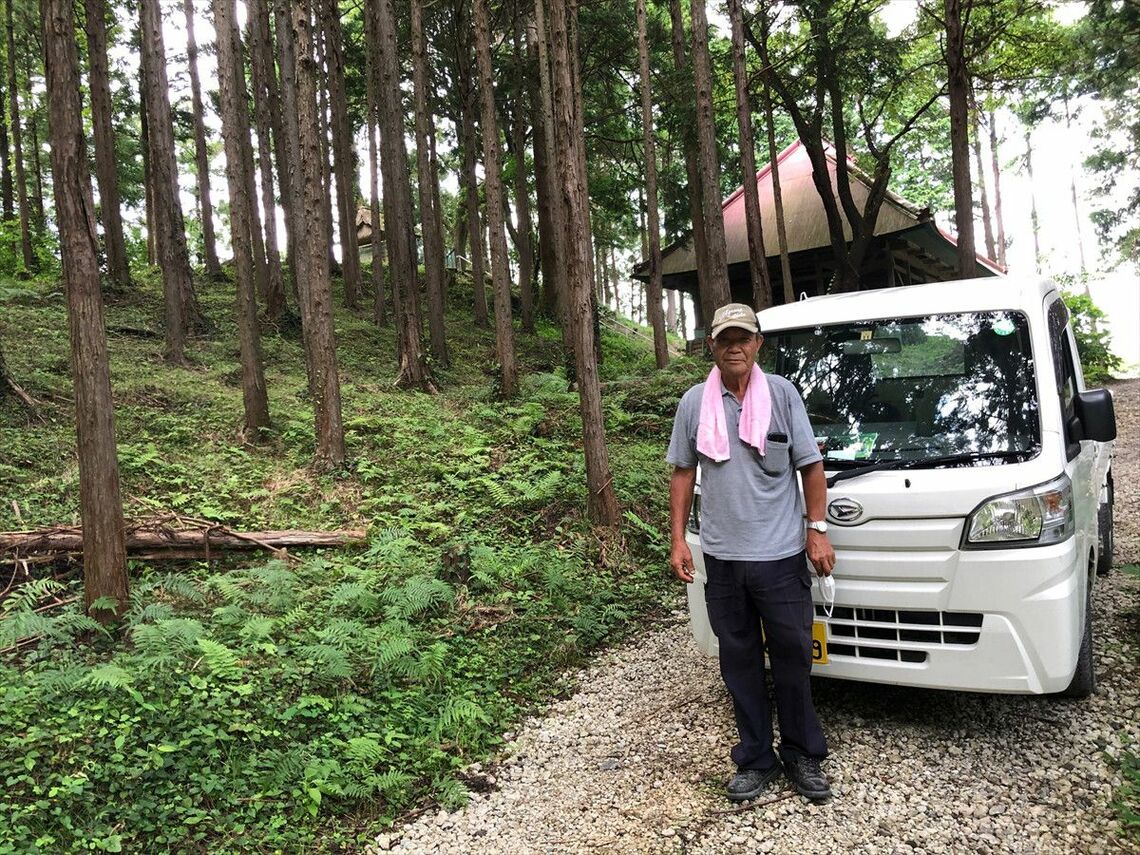 取材に協力してくれた細野地区の区長 川木利夫さん。地区の皆さんが大切に守っている愛宕神社の前にて（筆者撮影）
