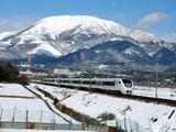 冠雪した伊吹山をバックに雪景色の中を駆け抜ける特急「しらさぎ」（撮影：南正時）