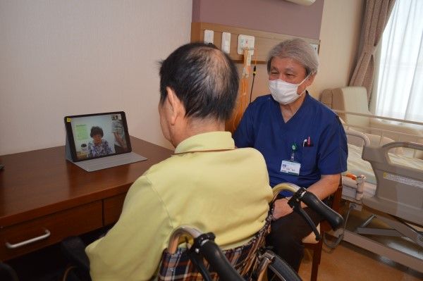 卓上に置かれたタブレット端末で、家族とオンライン面会中の入所者（写真：筆者撮影）