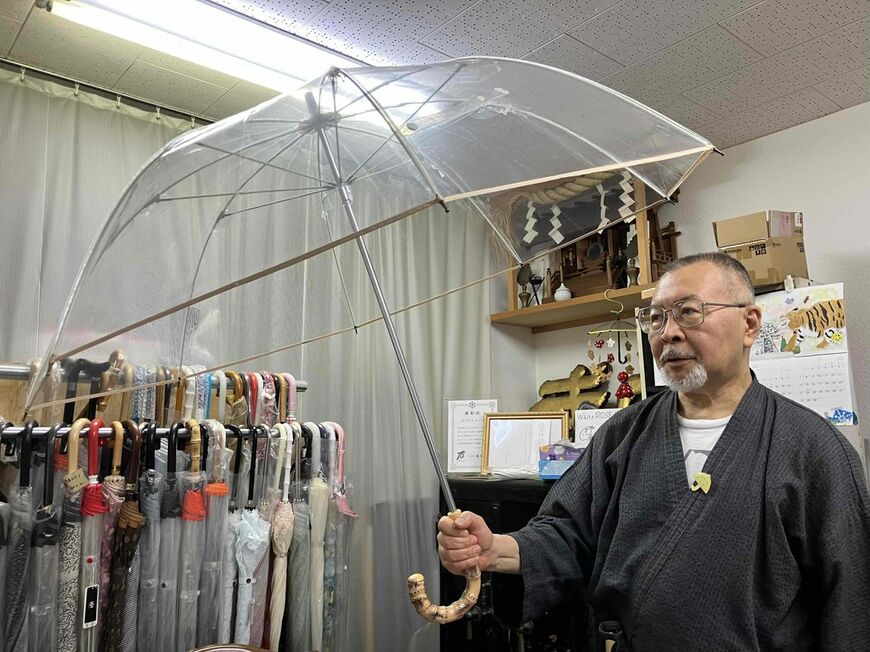 こだわりの高級ビニール傘を手にする須藤宰社長（写真：筆者撮影）