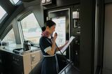 「伊予灘ものがたり」のアテンダント、大久保実奈さんが車内アナウンスのリハーサル（記者撮影）