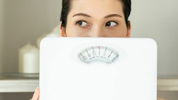 体重計を持つ女性