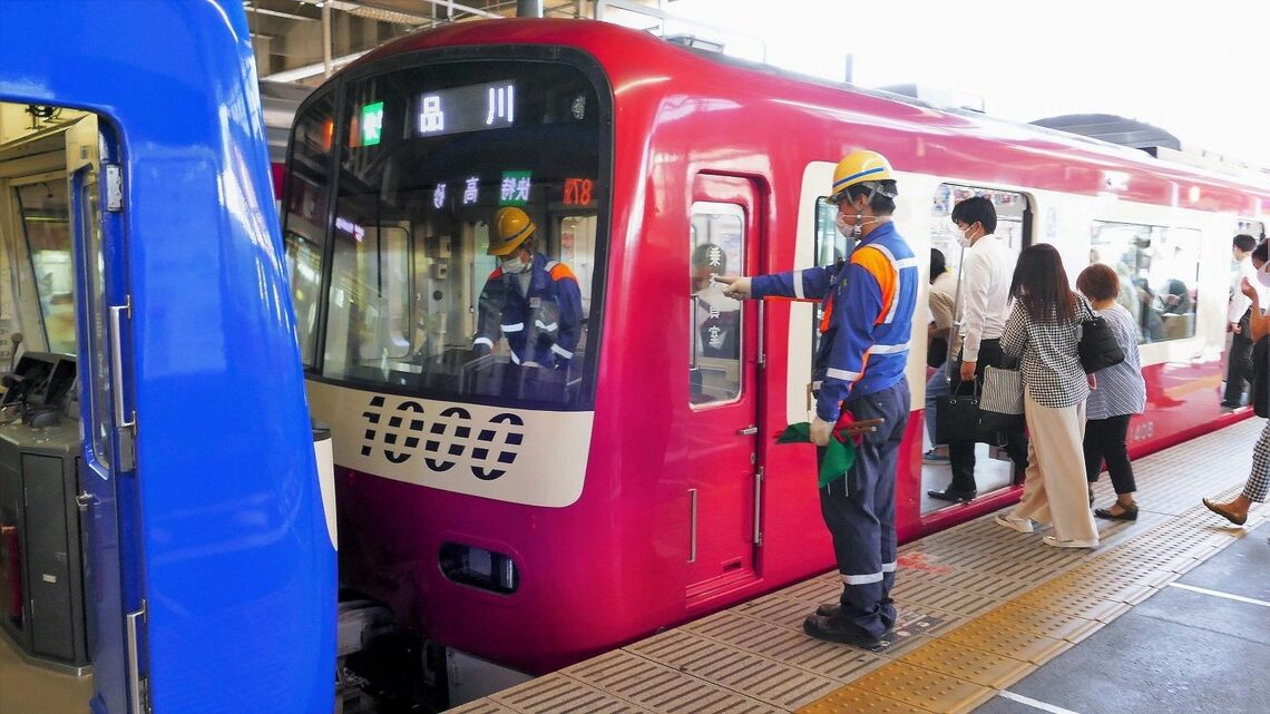 京急の金沢文庫駅3番線で快特（8両編成）の後ろに空の4両編成を増結する作業（記者撮影）