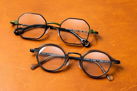 メンズにおすすめの眼鏡2本。緑色がアクセントとなっている眼鏡とフレーム上部など一部がべっこう柄の眼鏡