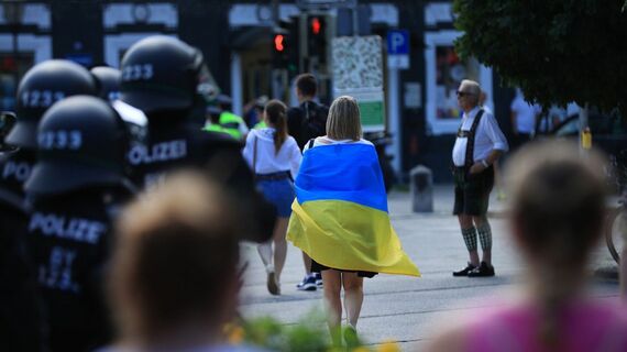 2022年6月にドイツで開かれたG7首脳サミットでウクライナの国旗を掲げ、デモ行進する女性