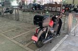 都内のバイク駐車場にて。ヘルメットを収納するためリアキャリアにボックスを装着した（筆者撮影）