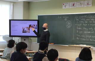 英語の授業。外国籍の教員がプレゼンテーションの仕方を説明