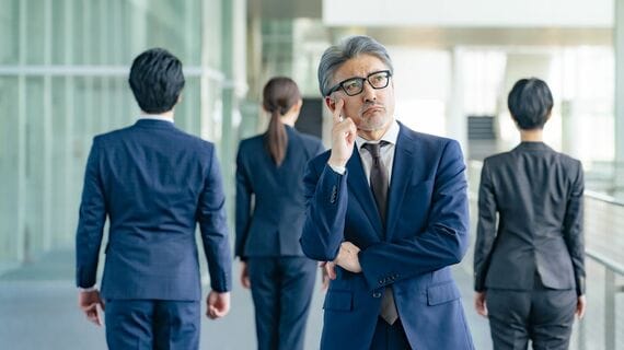 部下に背を向けて悩む上司