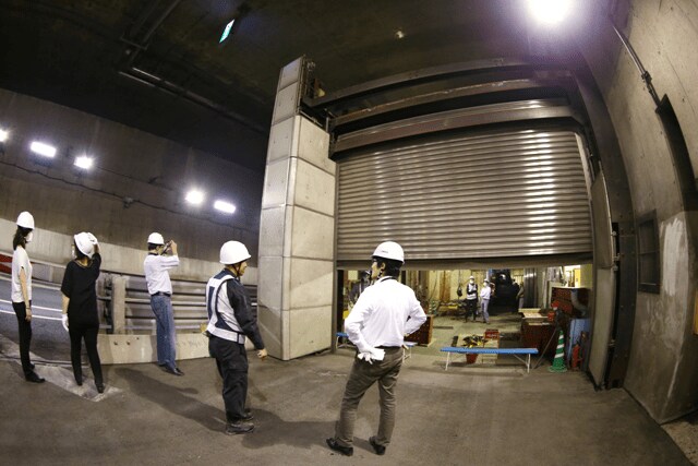 画像を拡大 		外に出て振り返ると、シャッターの向こうが工事現場だ