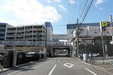 松が峰教会通りを渡る東武宇都宮線の電車。左奥がプラザパーキング（記者撮影）