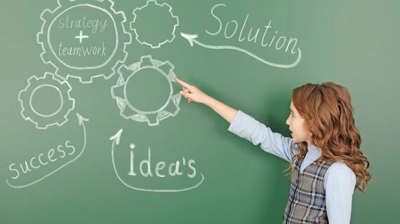 黒板に図を描く女の子