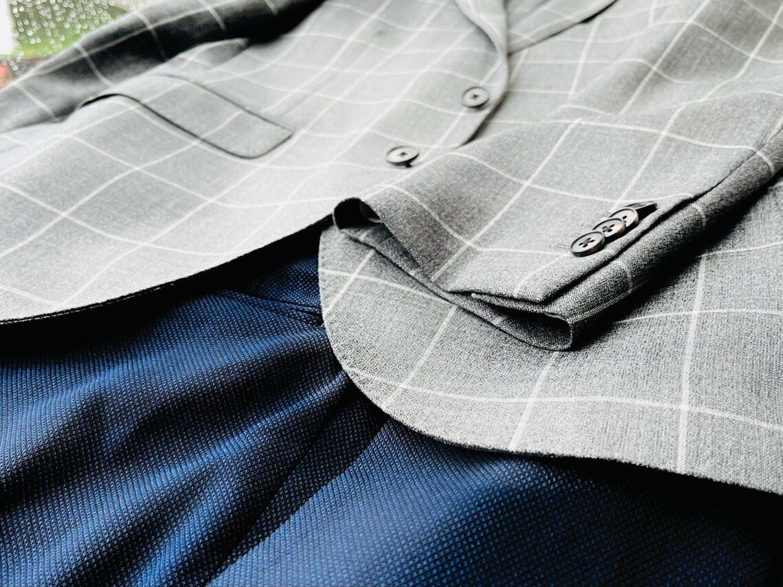 違和感を隠し切れない「ウールジャケットに合わせた」テカテカ系スラックス（写真：筆者撮影）