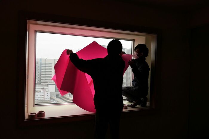 窓に紙を貼り付ける作業