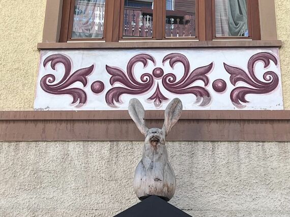 装飾された窓枠と、屋根に乗せられた木彫りのウサギ
