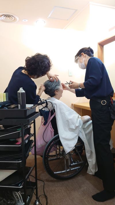 美容スタッフによるメイクも細山看護師が見守る（写真はケアミックス提供）