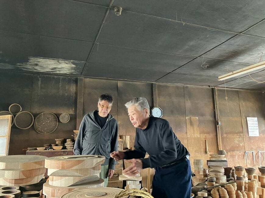 椀木地などを作る刳物師の池下さん。震災前の工房で赤木さんと（写真：赤木明登）