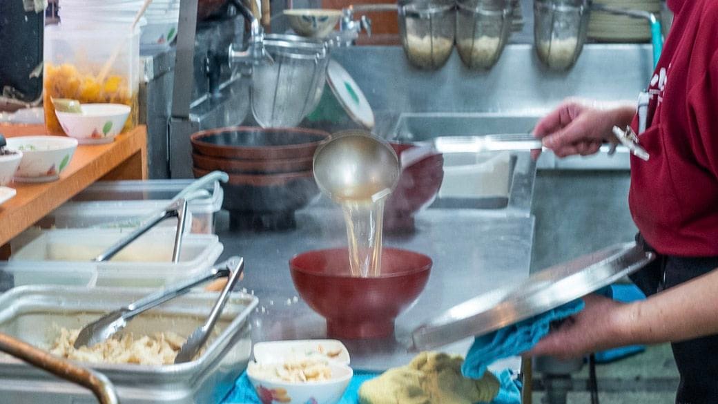 澄んだ出汁をお椀に注ぐ様子