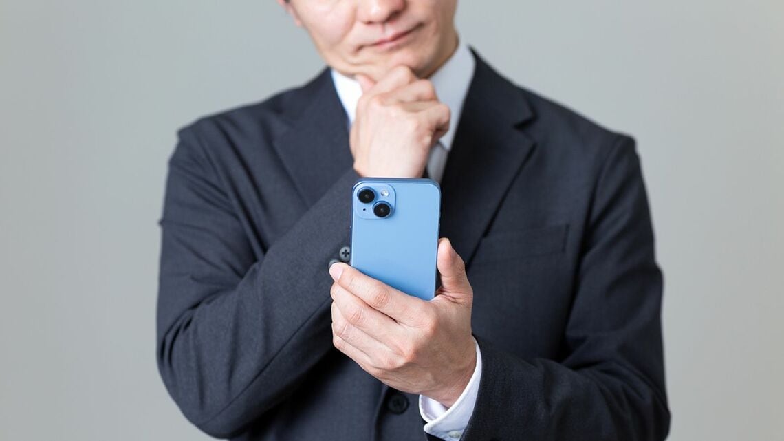 スマホを見て首を傾げる男性