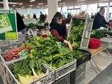 こちらの野菜は、手前がスイスチャード。ガーリックと一緒にシンプルに炒めると美味しい。女性が手にしているのはほうれん草。量り売りがマルシェのスタンダードだ（筆者撮影）