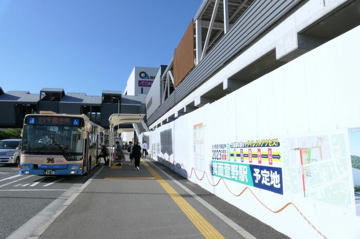 「かやの中央」のバス停と千里中央行きのバス