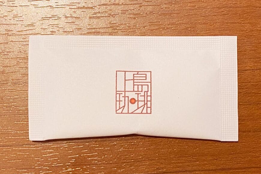 上島珈琲店の紙おしぼり。キャラクターなどはないシンプルなロゴマーク（筆者撮影）