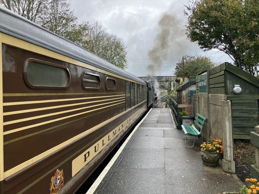 雨降る中を蒸気機関車に牽かれて走り去る「デボン・ベル」展望車（筆者撮影）