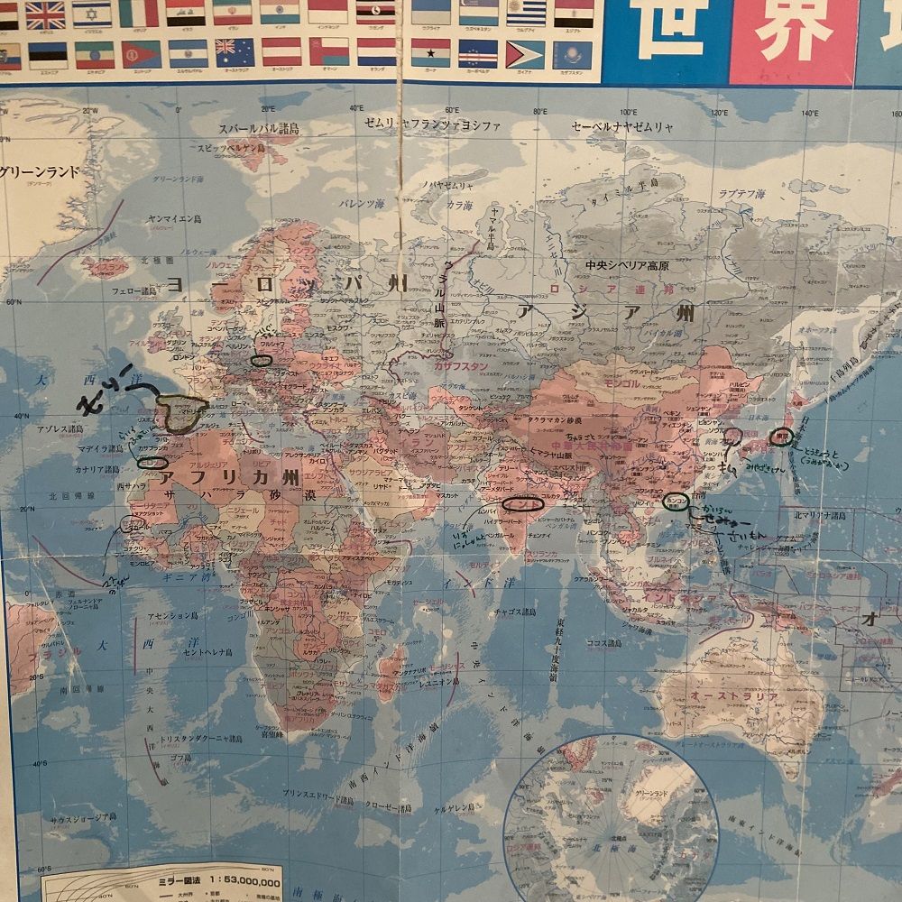 このご家庭のトイレに貼られた世界地図。これまで一緒に暮らしたことのある人々の出身地と名前が書き込まれている（写真：筆者撮影）
