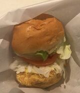チキンをサンドしたバーガーは日本オリジナルのメニュー。写真は「オリーブチキンバーガー」（390円）。鶏のささみをオリーブチキンと同様にスパイスで味付けし、特製フライオイルで揚げたチキンを挟んだ（筆者撮影）