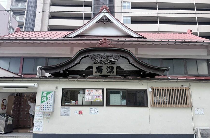 伝統的な宮造りの外観とえんじ色の唐破風屋根が特徴の寿湯（写真：筆者撮影）