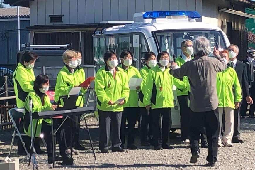 地域住民が作詞作曲した「グリスロ賛歌」を式典に集まった全員で合唱する様子（筆者撮影）
