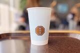 アイスコーヒーは、猿田彦のロゴが入ったシンプルなデザインの紙コップ入り（筆者撮影）