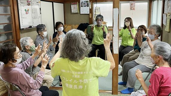 民家に集まり体操をする高齢者とスタッフ