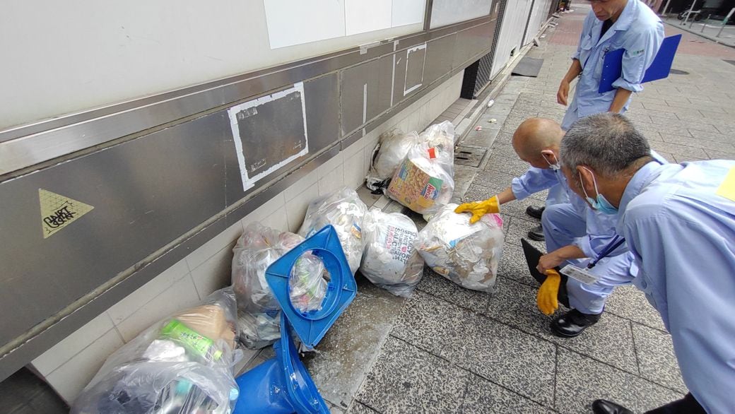 排出者の特定が可能か確認する清掃職員（筆者撮影）