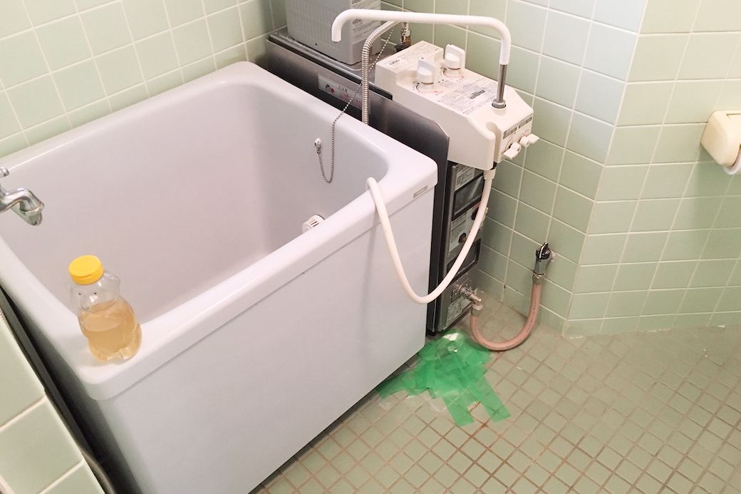 お風呂場は昭和レトロなバランス釜。引っ越し直後は、排水口のトラップが壊れていて悪臭がすごかったため、テープで封印していました（筆者撮影）