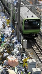 電車の接近時は作業員が旗を振って注意喚起