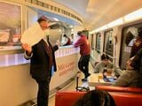 「レールジェット」の食堂車カウンターで乗客と歓談する検札中の車掌（筆者撮影）