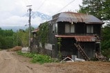 廃屋と羊蹄山。山林を切り開いた場所だが、工事車両が行き交っていた（写真：筆者撮影）