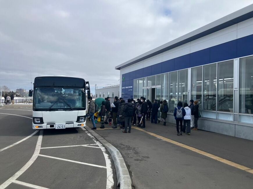 シャトルバスに乗り換え工場見学に向かうツアー客（筆者撮影）