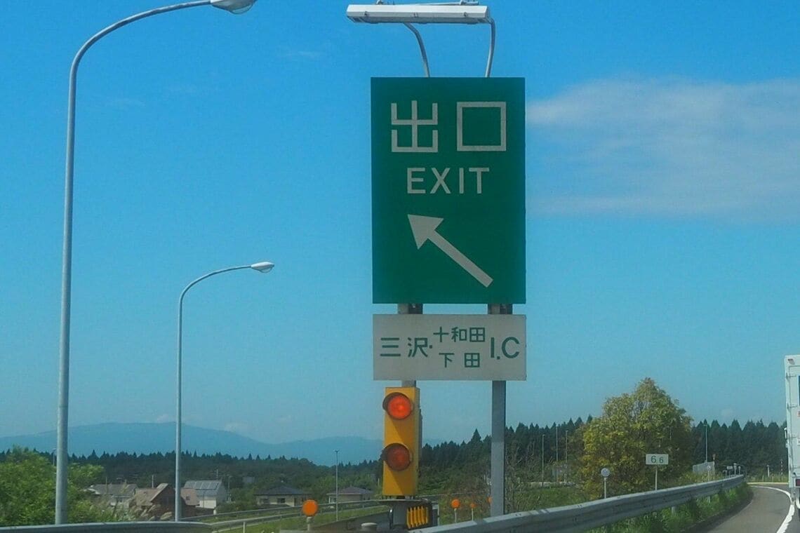 1行に収まらず2行にわたって記述されている「三沢十和田下田IC」の案内標識（筆者撮影）